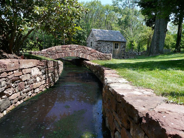 Stone walls along creek with stone bridge