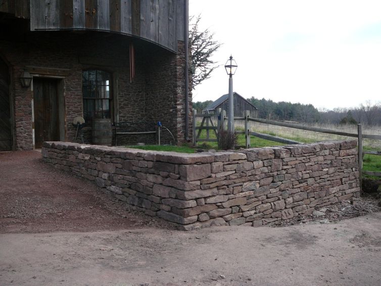 Stone wall in front of stone barn