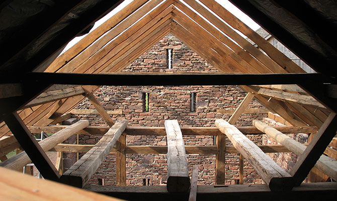 Interior of stone barn and new roof beams and rafters