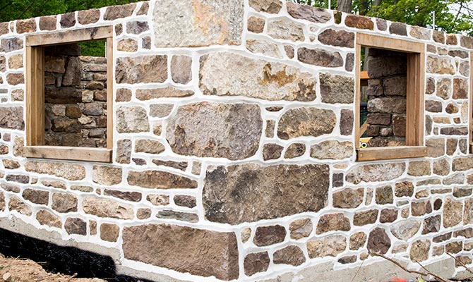 Stone barn foundation with two window openings and ridge pointing finish